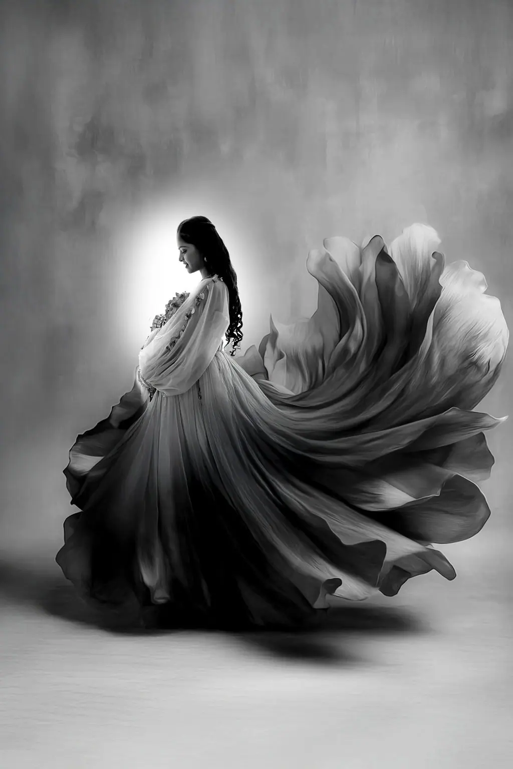 Expectant mother in a flowing gown swirling like petals on a painted backdrop, maternity photoshoot at WonderBump Studio, Bengaluru
