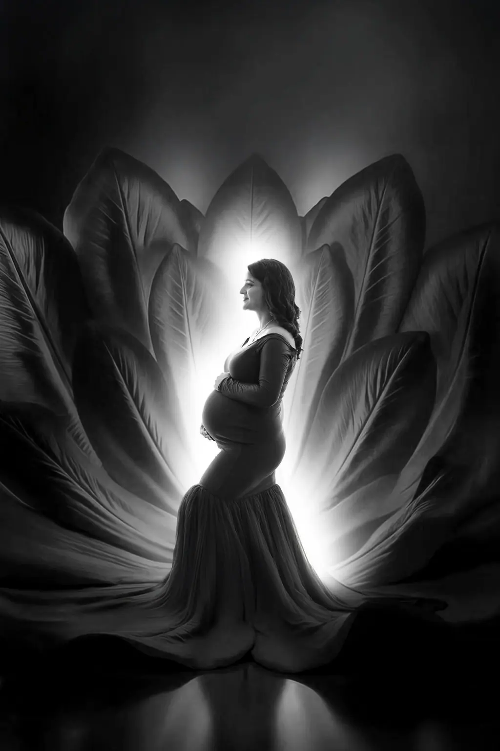 Expectant mother in profile in a fitted gown before glowing painted petals, maternity photoshoot at WonderBump Studio, Bengaluru