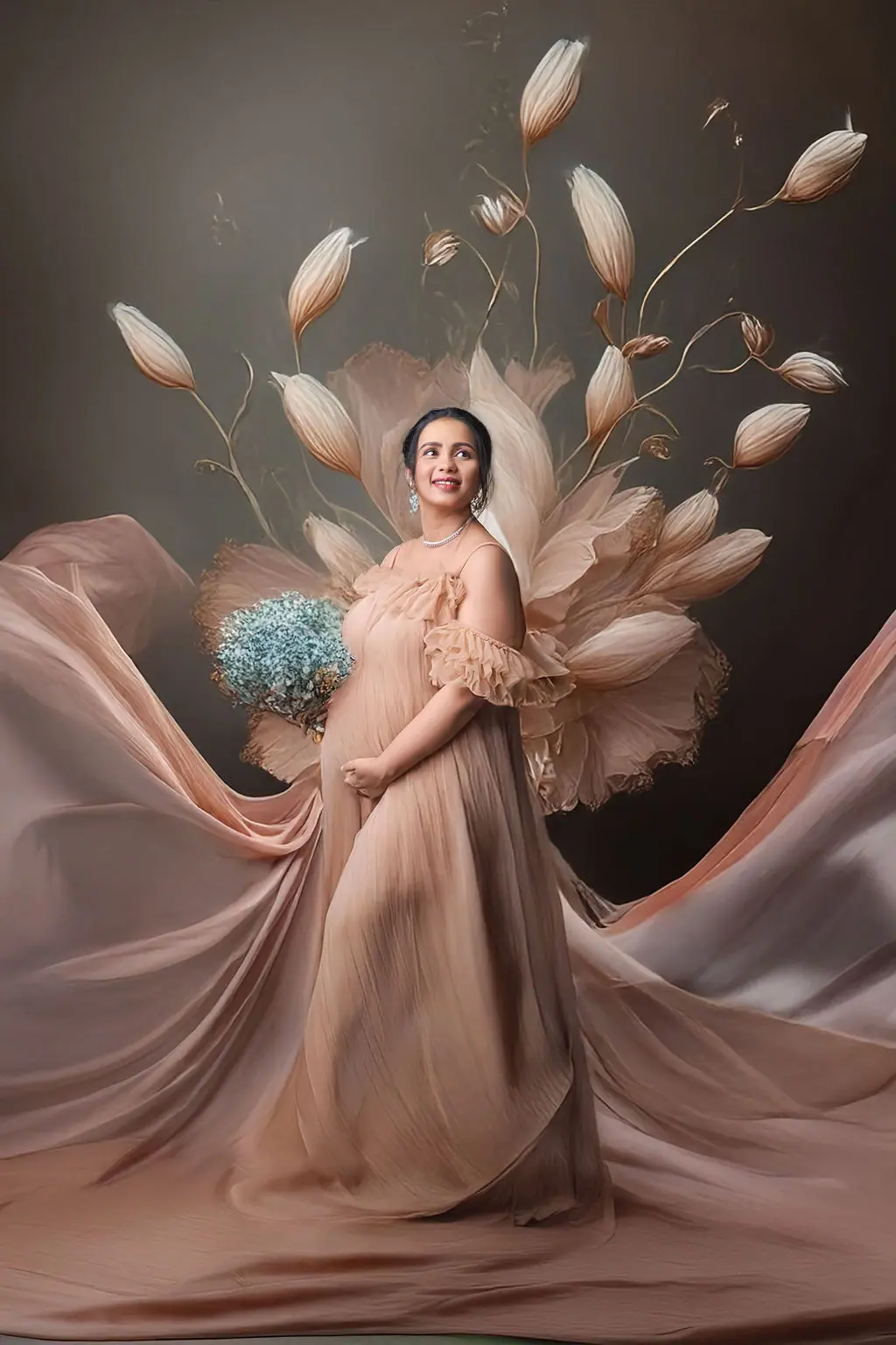 Smiling expectant mother in a blush ruffled gown with a flower bouquet, painted floral backdrop, maternity photoshoot at WonderBump Studio, Bengaluru
