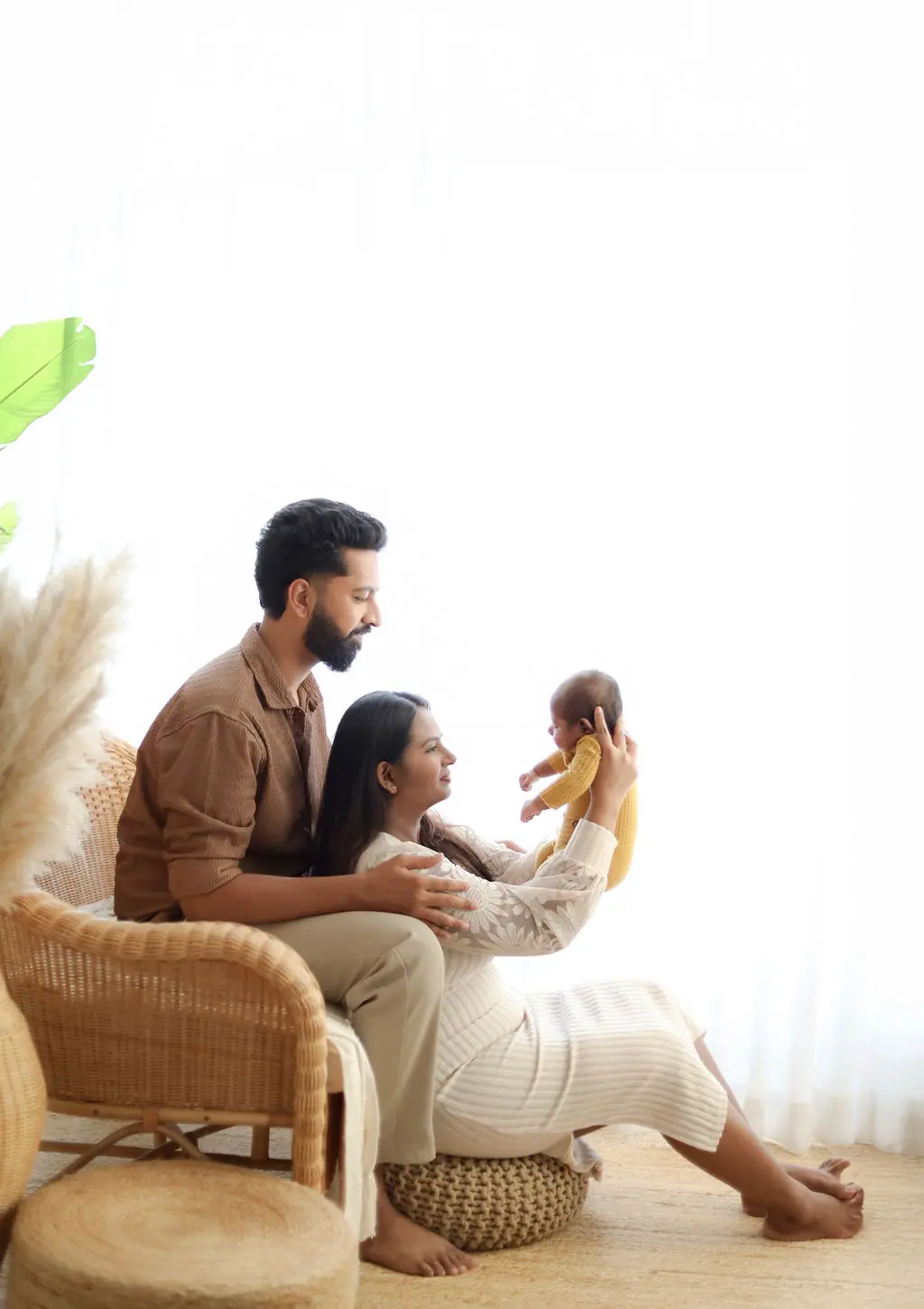 A mother and father lifting their newborn during a WonderBump Studio session in Bengaluru.